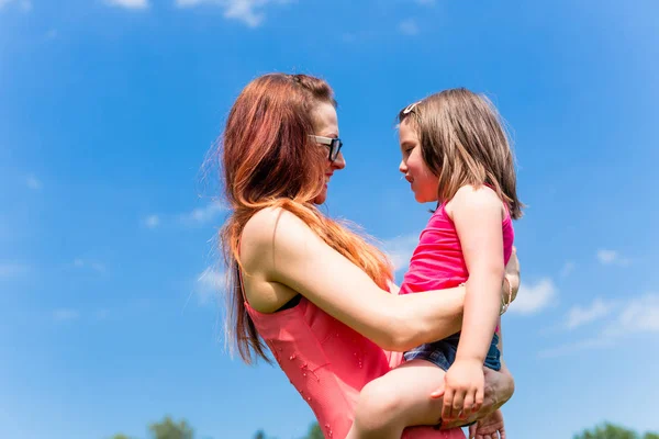 Mãe segurando sua filha nos braços — Fotografia de Stock