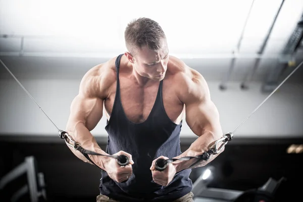 Bodybuilder doing butterfly on cable pull — Stock Photo, Image