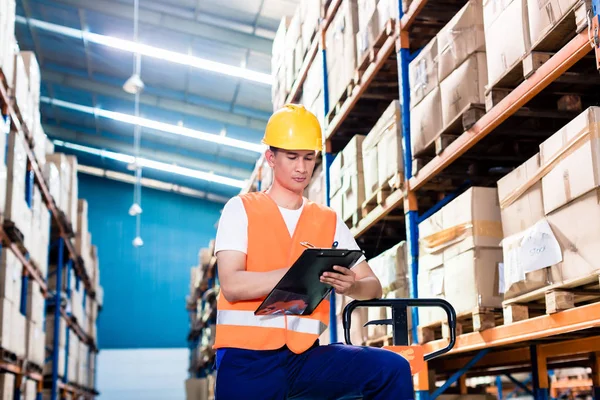 Asian man in industrial warehouse — Stock Photo, Image