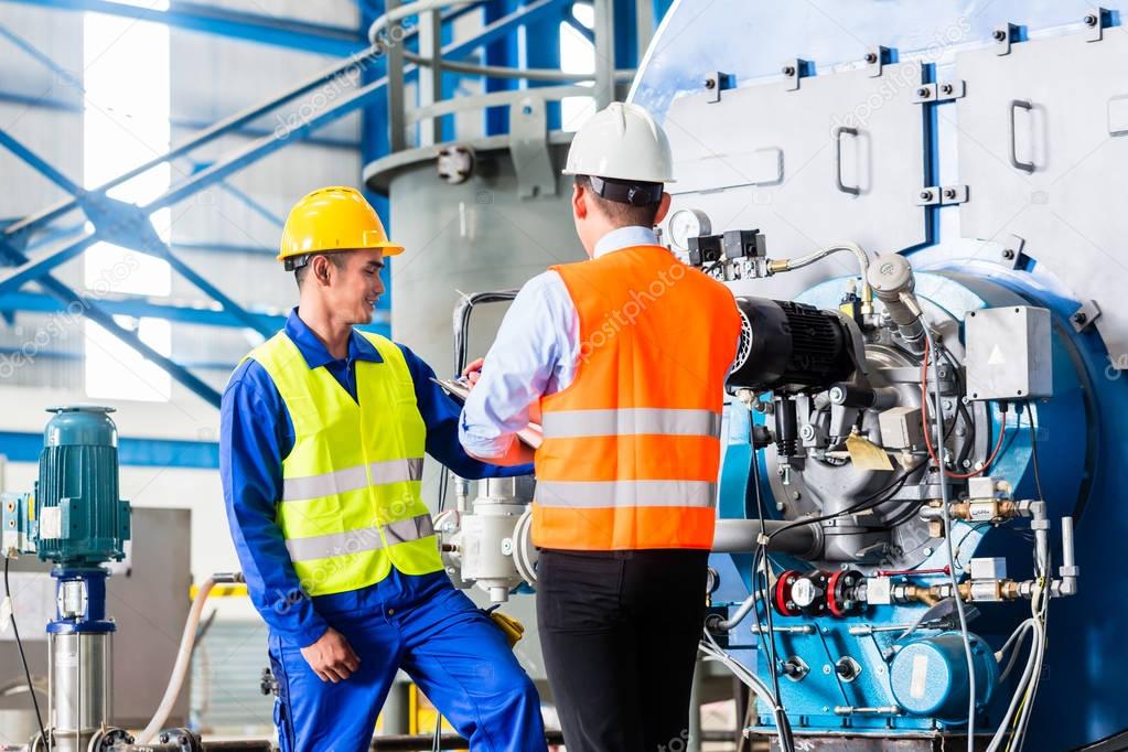 Worker and manager in industrial factory 