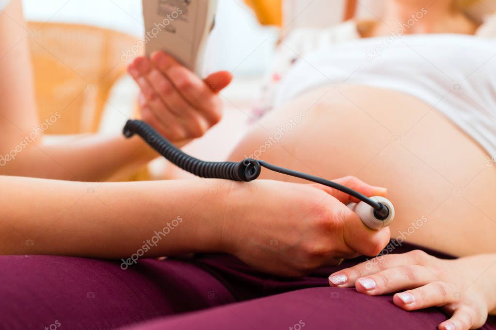 Midwife seeing mother for pregnancy examination