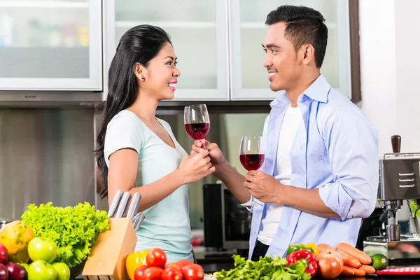 Asiático casal beber vinho tinto na cozinha — Fotografia de Stock