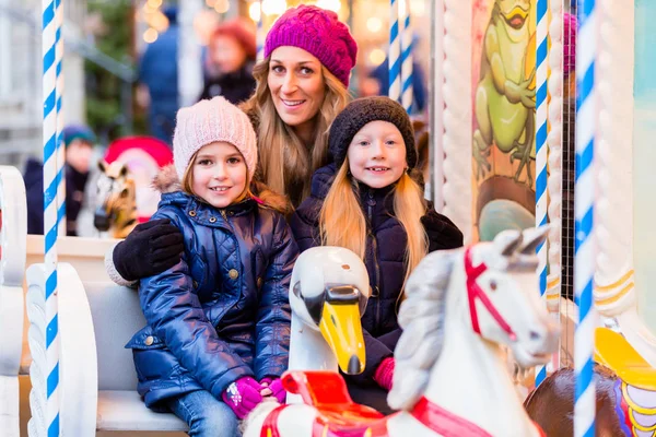 Family riding the carousel — Stock Photo, Image