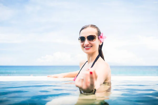 Nő, ami a végtelen-medence szélén udvarlás gesztus — Stock Fotó