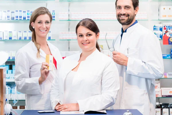 Equipo de farmacéuticos en farmacia que revisa productos farmacéuticos —  Fotos de Stock