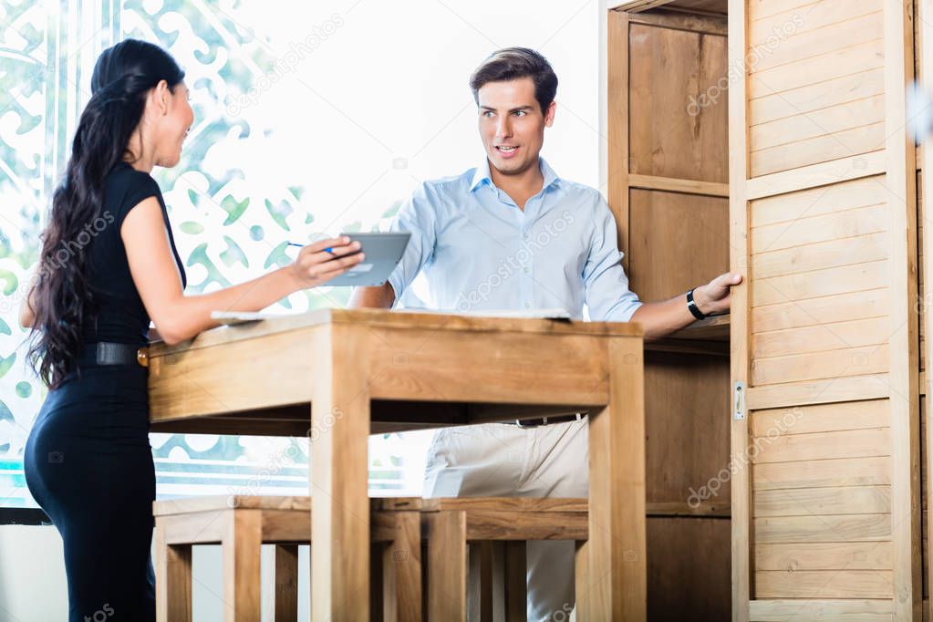 Couple in furniture store checking price 