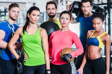 Group of women and men in gym posing at fitness training clipart