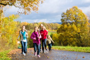 Family take walk in autumn forest clipart