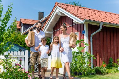 Evine gelen araba yiyecek taşıyan aile