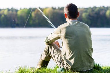 Onun çubuk ile Göl Balıkçılık çimlere oturup fener