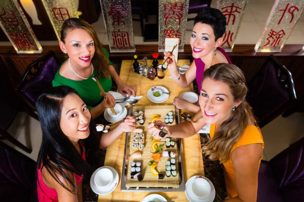 Mladí lidé jíst sushi — Stock fotografie