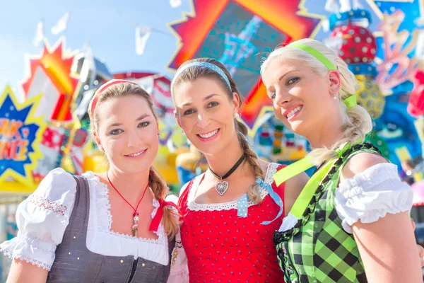 Amigos que visitam feira bávara se divertindo no carrossel — Fotografia de Stock