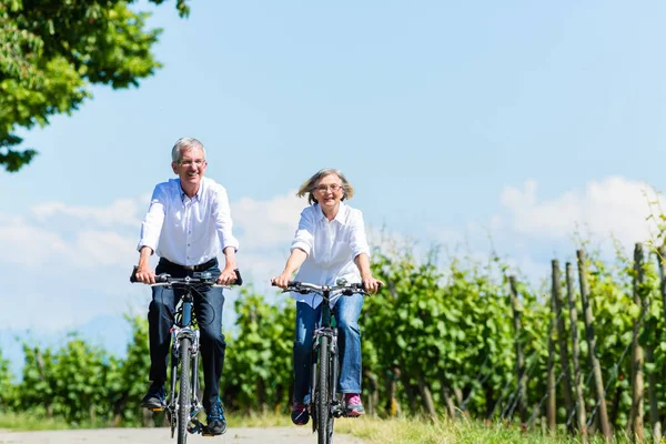 Seniorin und Mann benutzen Fahrrad — Stockfoto