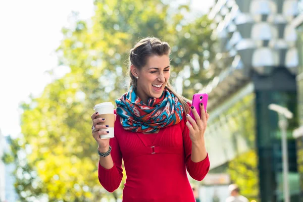 Женщина с кофе и телефоном в городе — стоковое фото