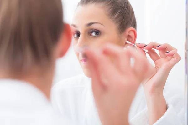 Woman cleaning her ears with cotton bud — Stock Photo, Image