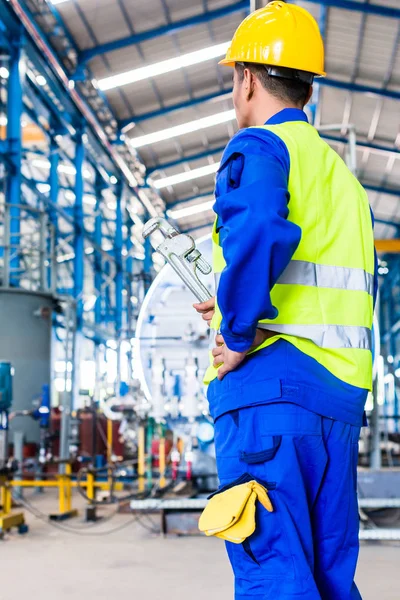 Industriële werknemer in fabriek met hulpmiddelen — Stockfoto