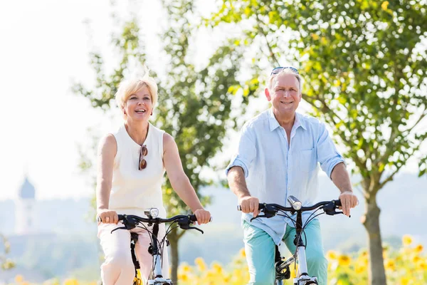 Senior couple riding their bikes — Stock Photo, Image