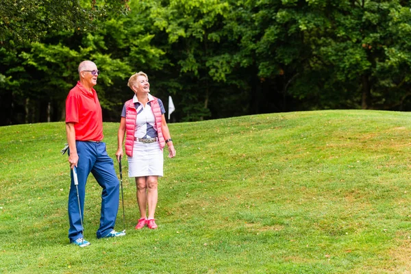 Старшая пара играет в гольф — стоковое фото