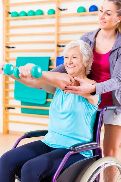 Mulher idosa na cadeira de rodas fazendo fisioterapia — Fotografia de Stock