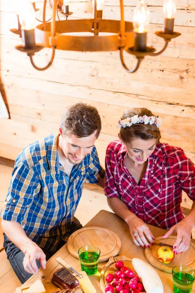 Mann und Frau essen Essen in Berghütte — Stockfoto