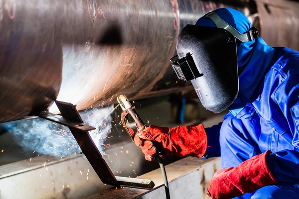 Welder in factory welding metal pipes — Stock Photo, Image