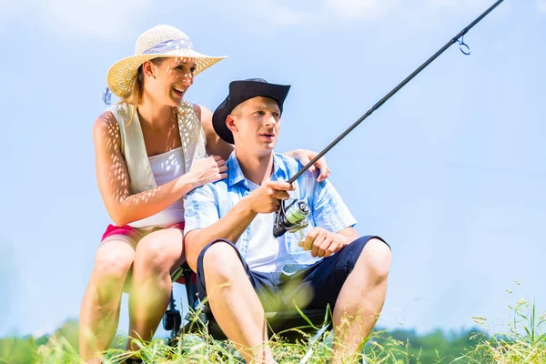 Homem com haste de pesca angling no lago apreciando abraço — Fotografia de Stock