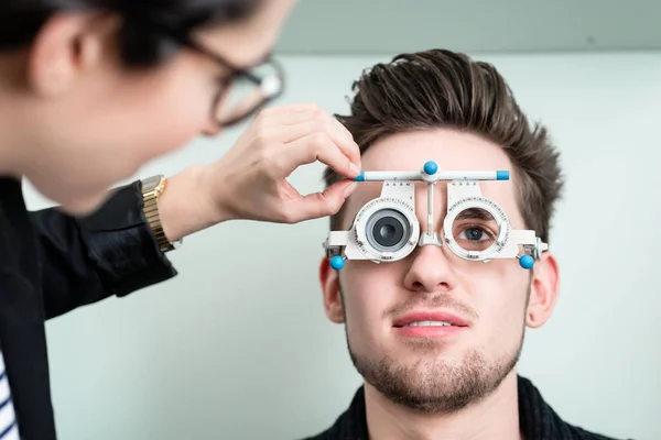 Человек с оптиком на тесте зрения для очков — стоковое фото