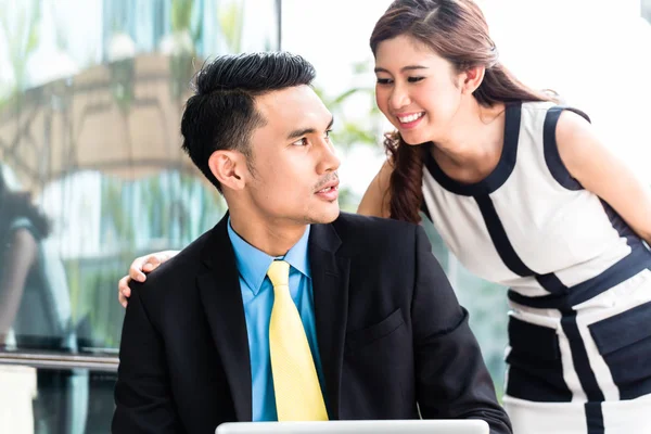 Asian businesspeople working outside on laptop — Stock Photo, Image