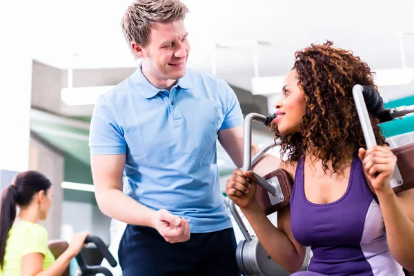 Femme africaine dans la salle de gym exercice avec entraîneur personnel — Photo