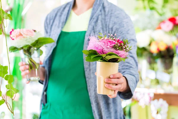 Florista trabalhando em loja de flores com plantas de panela — Fotografia de Stock