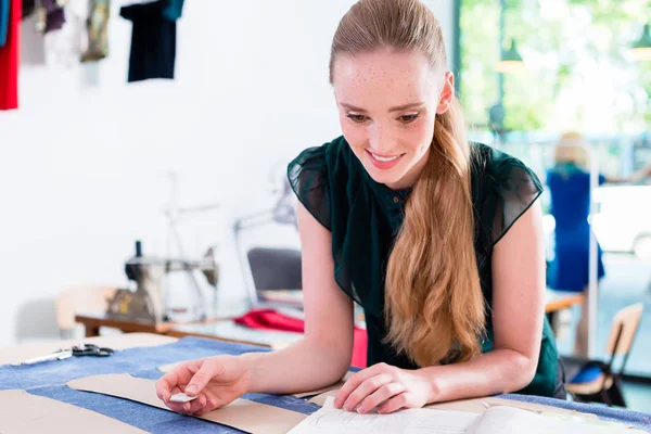 Tailor transfers pattern to cloth — Stock Photo, Image