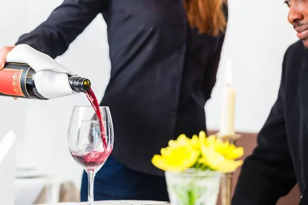 Servitrisen hälla vin i glas på fin restaurang — Stockfoto