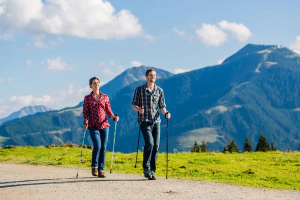 Pár nordic walking csinál gyakorlás-ban hegyek — Stock Fotó
