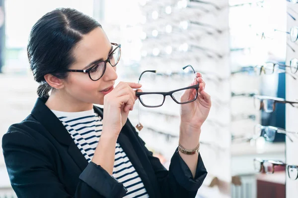 Женщина снимает очки с полки — стоковое фото