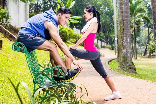 Mujer y hombre haciendo ejercicio en el parque en el banco — Foto de Stock