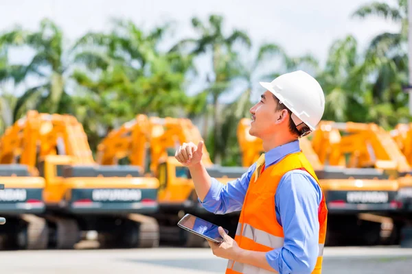 Asiatischer Ingenieur prüft Pläne — Stockfoto