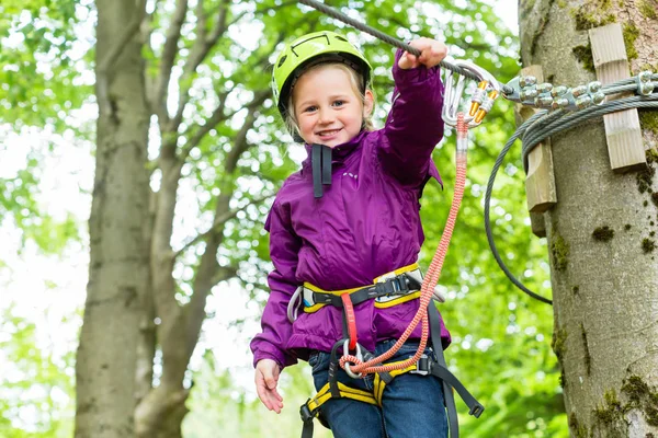 Girl climbing in high rope course — Stock Photo, Image