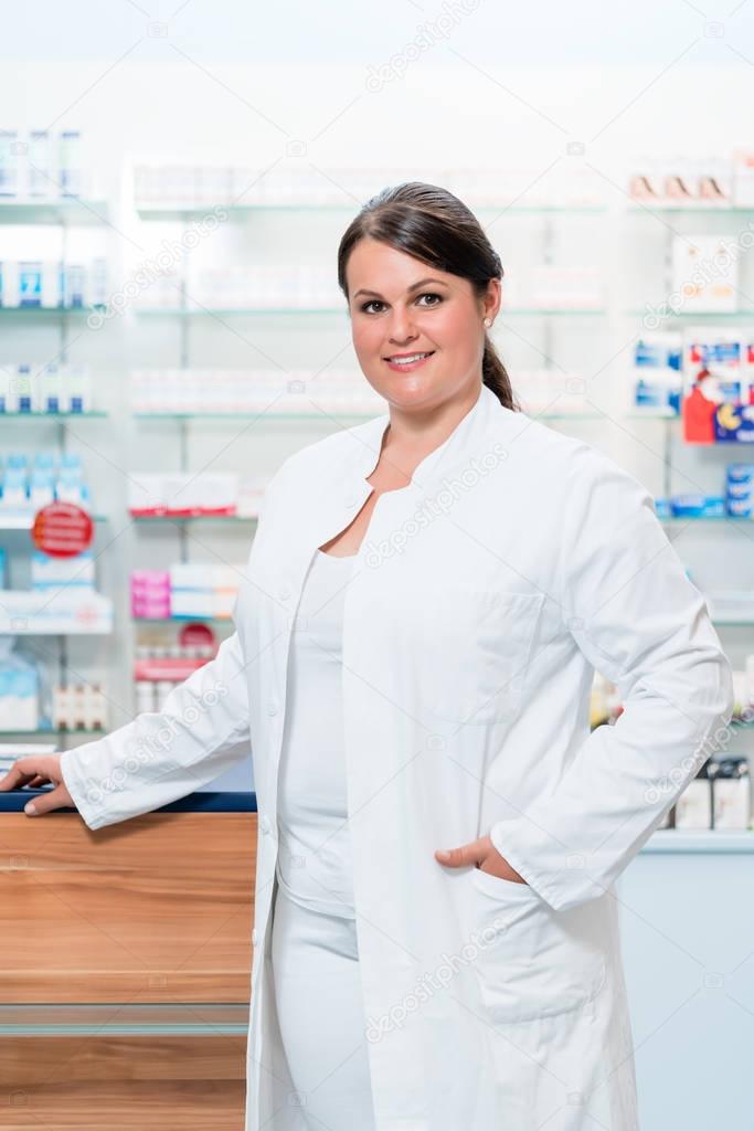 Pharmacist in chemist shop looking at camera