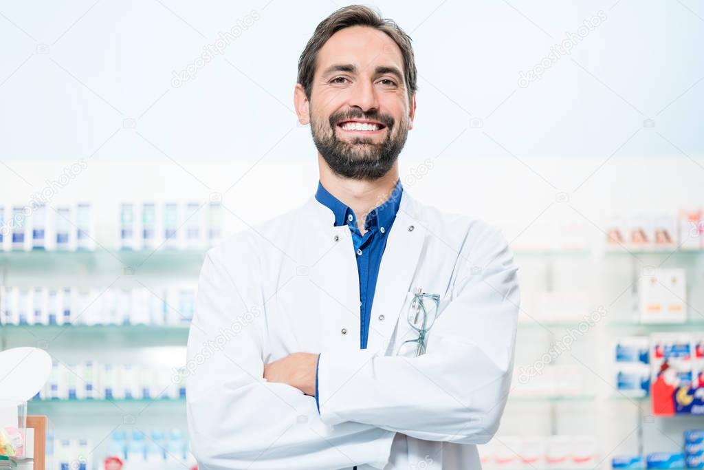 Apothecary in pharmacy standing at shelf