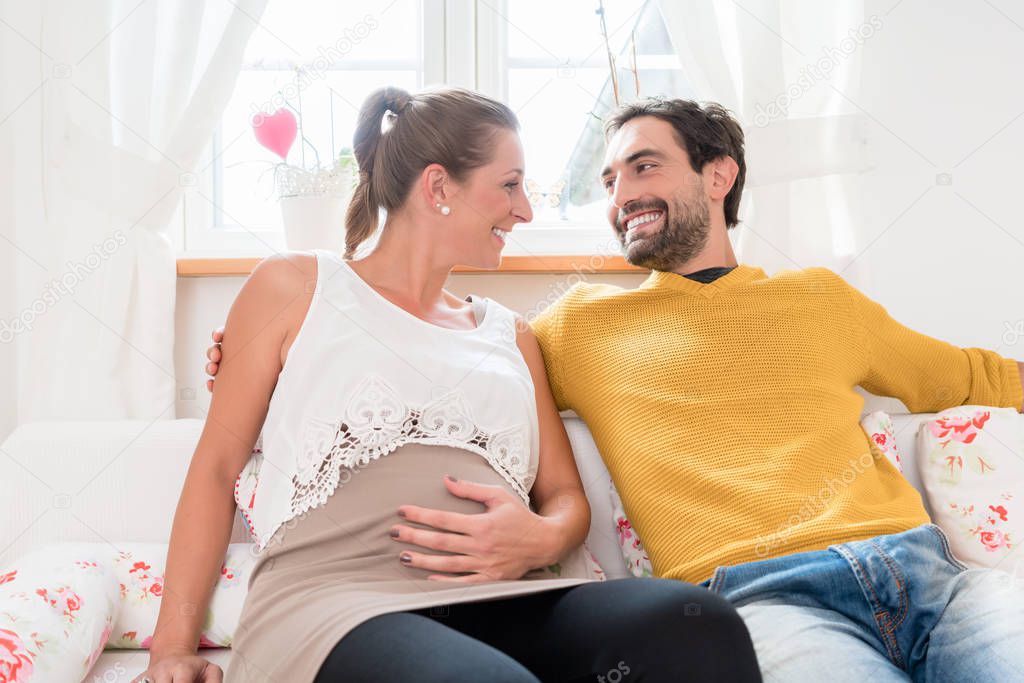 Parents-to-be smiling happily at each other