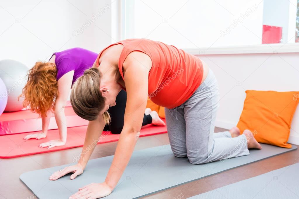 Two pregnant women exercising during prenatal class