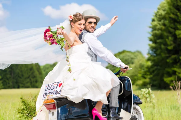 คู่แต่งงานบนรถมอเตอร์สกู๊ตเตอร์เพิ่งแต่งงาน — ภาพถ่ายสต็อก