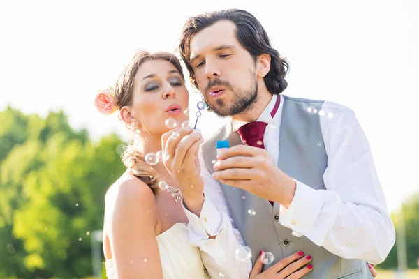 Matrimonio sposa e sposo soffiando bolle — Foto Stock