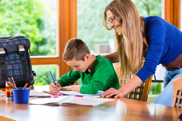 Mamma hjälper till med skolan hemuppgift — Stockfoto