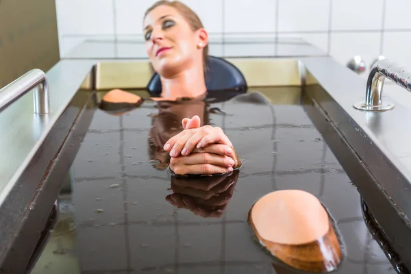 Senior woman enjoying mud bath — Stock Photo, Image