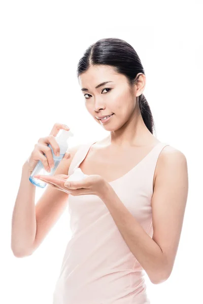 Jonge Aziatische vrouw gieten op hand cosmetische schuim — Stockfoto