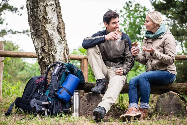 Casal em caminhada descansando debaixo da árvore — Fotografia de Stock