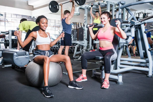 Mujer y hombres se divierten haciendo deporte de fitness en el gimnasio — Foto de Stock