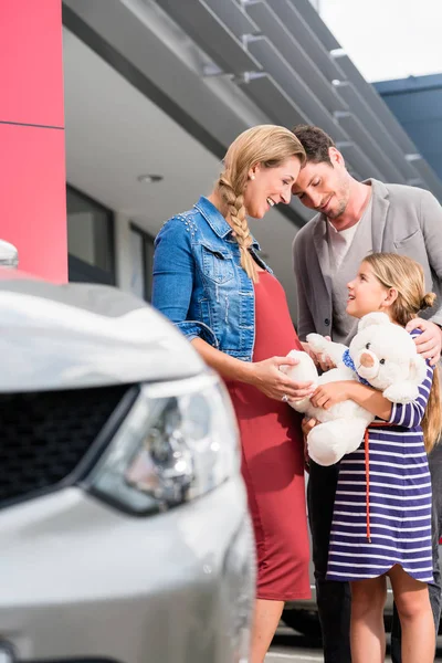 Семья с дочерью купить автомобиль — стоковое фото