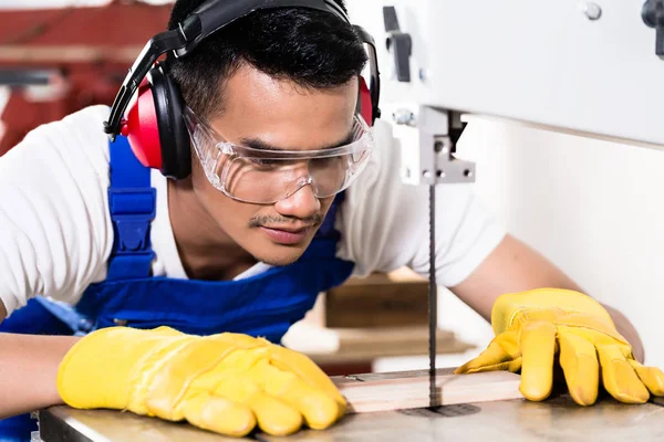 Asian carpenter or worker on saw with wood — Stock Photo, Image